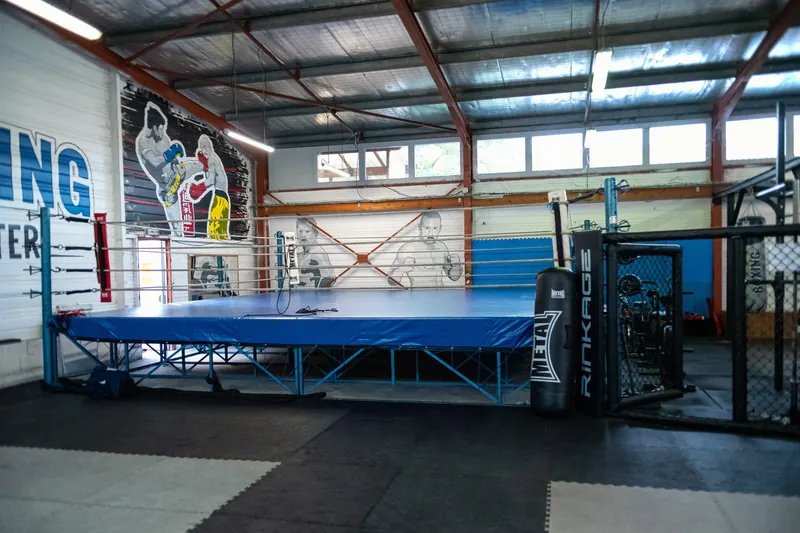 Le ring de boxe aux cordes bleues sous la grande fresque Boxing Center