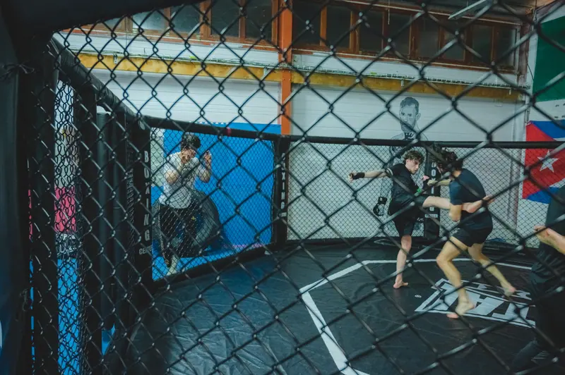Entraînement de MMA dans l'octogone grillagé du Boxing Center Ramonville.