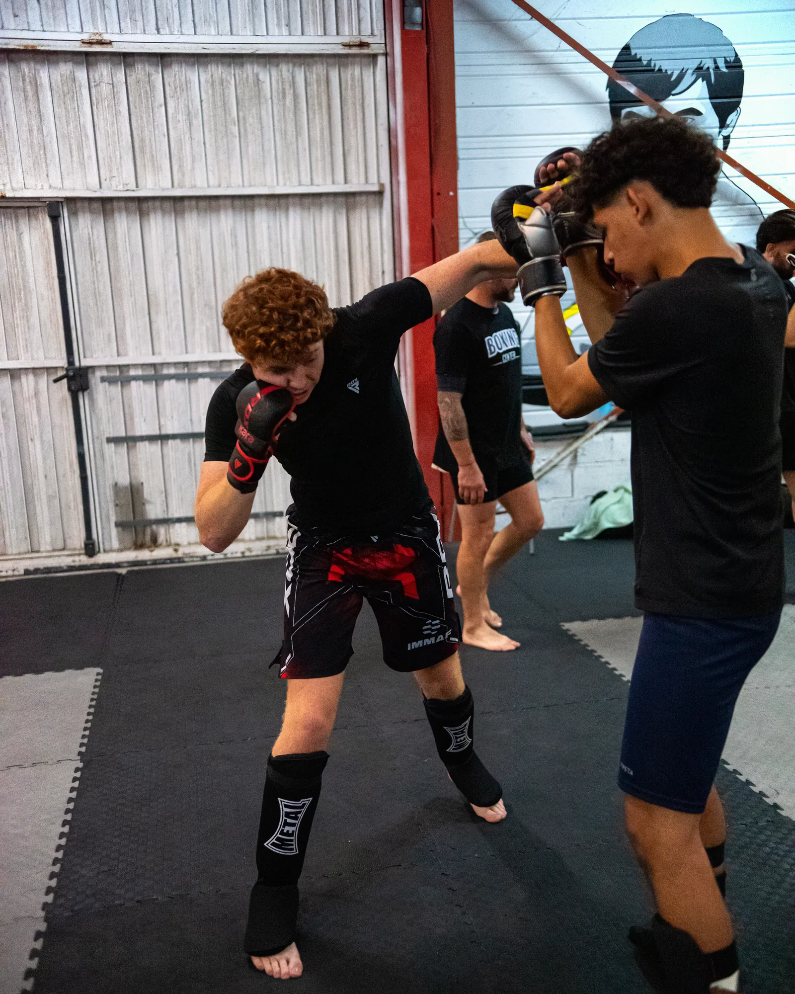 Deux pratiquants travaillent les frappes en binôme pendant le cours de MMA au Boxing Center Ramonville